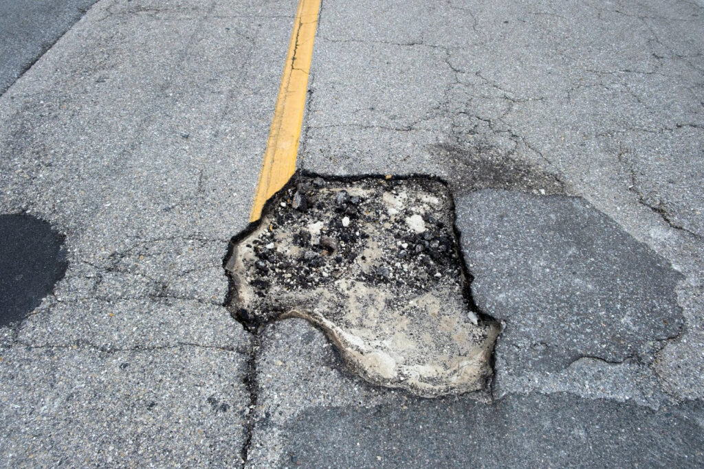 damaged-asphalt-road-with-deep-pothole-on-american-2026-01-06-10-00-23-utc