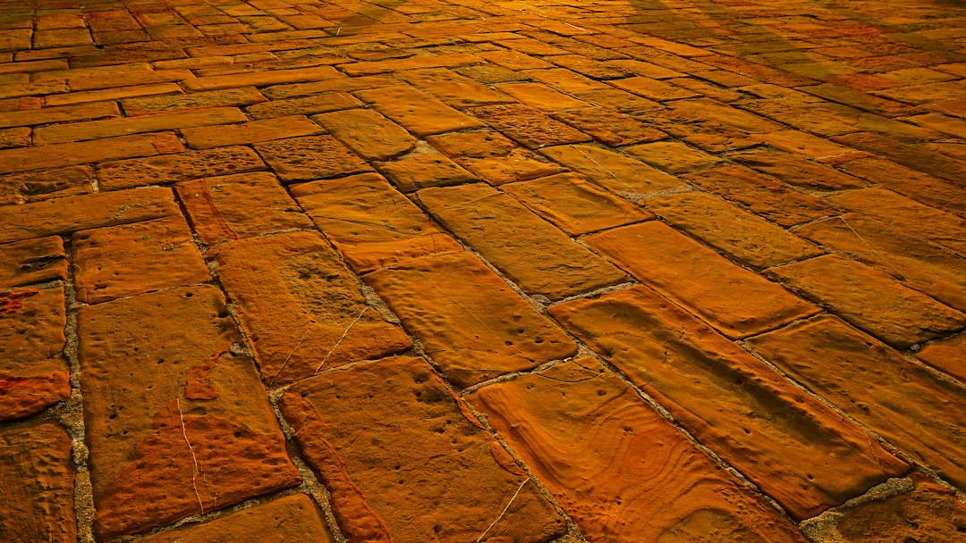 A classic red clay paver walkway winding through a lush green backyard - backyard brick design A classic red clay paver walkway winding through a lush green backyard - backyard brick design