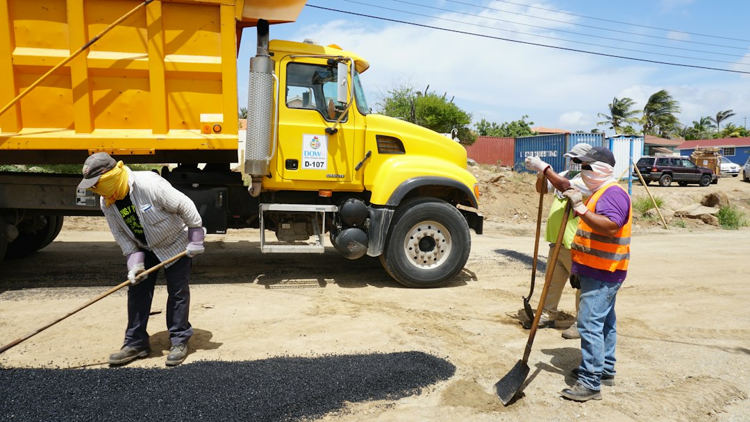 Professional crew preparing a compacted aggregate sub-base for a new walkway