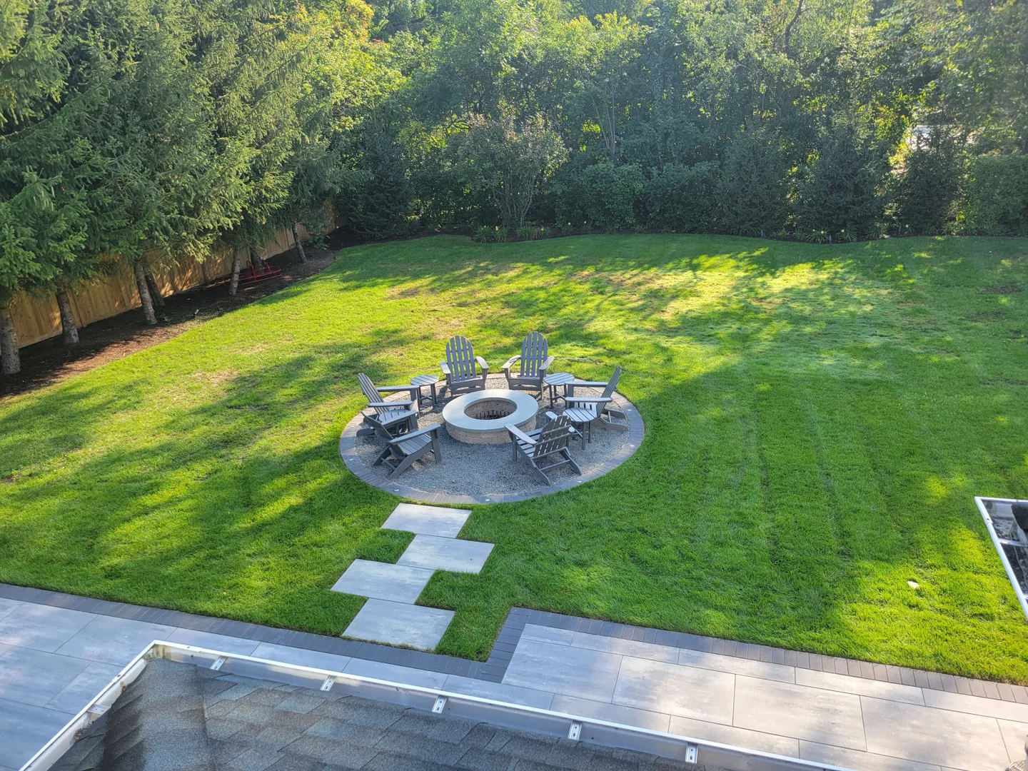 concentric circular red brick patio surrounding stone fire pit at dusk concentric circular red brick patio surrounding stone fire pit at dusk