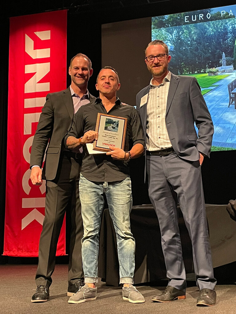Wojciech Chrzanowski of Euro Paving holding the Unilock Awards of Excellence plaque
