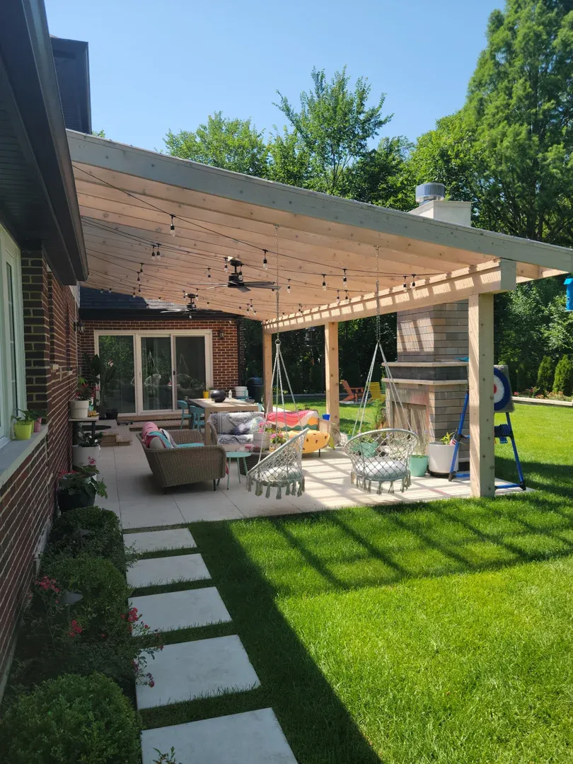 Backyard patio with custom stone outdoor kitchen cedar pergola and seating